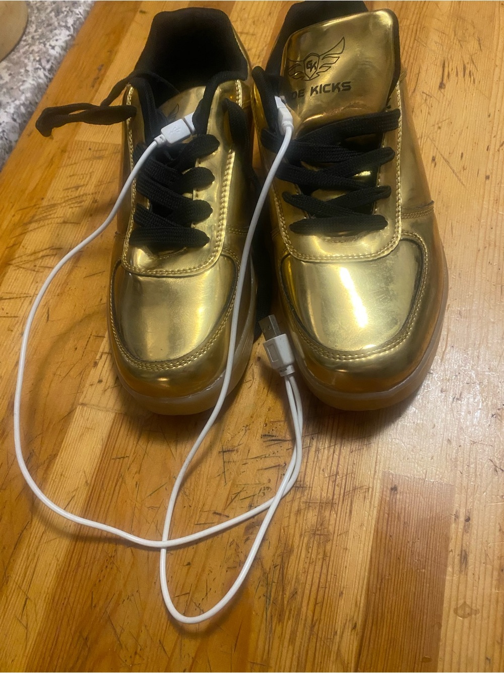 Gold Metallic Women's Sneakers with Black Laces light up with wires to charge.